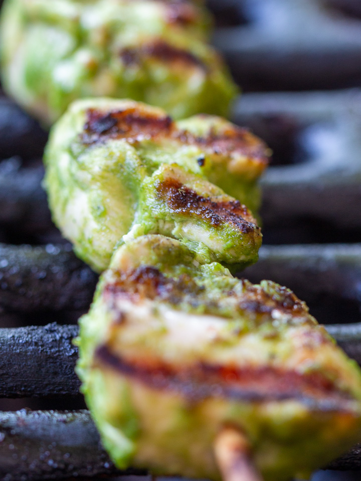 Close up shot of a green chicken kabab on the grill with delicious grill marks.