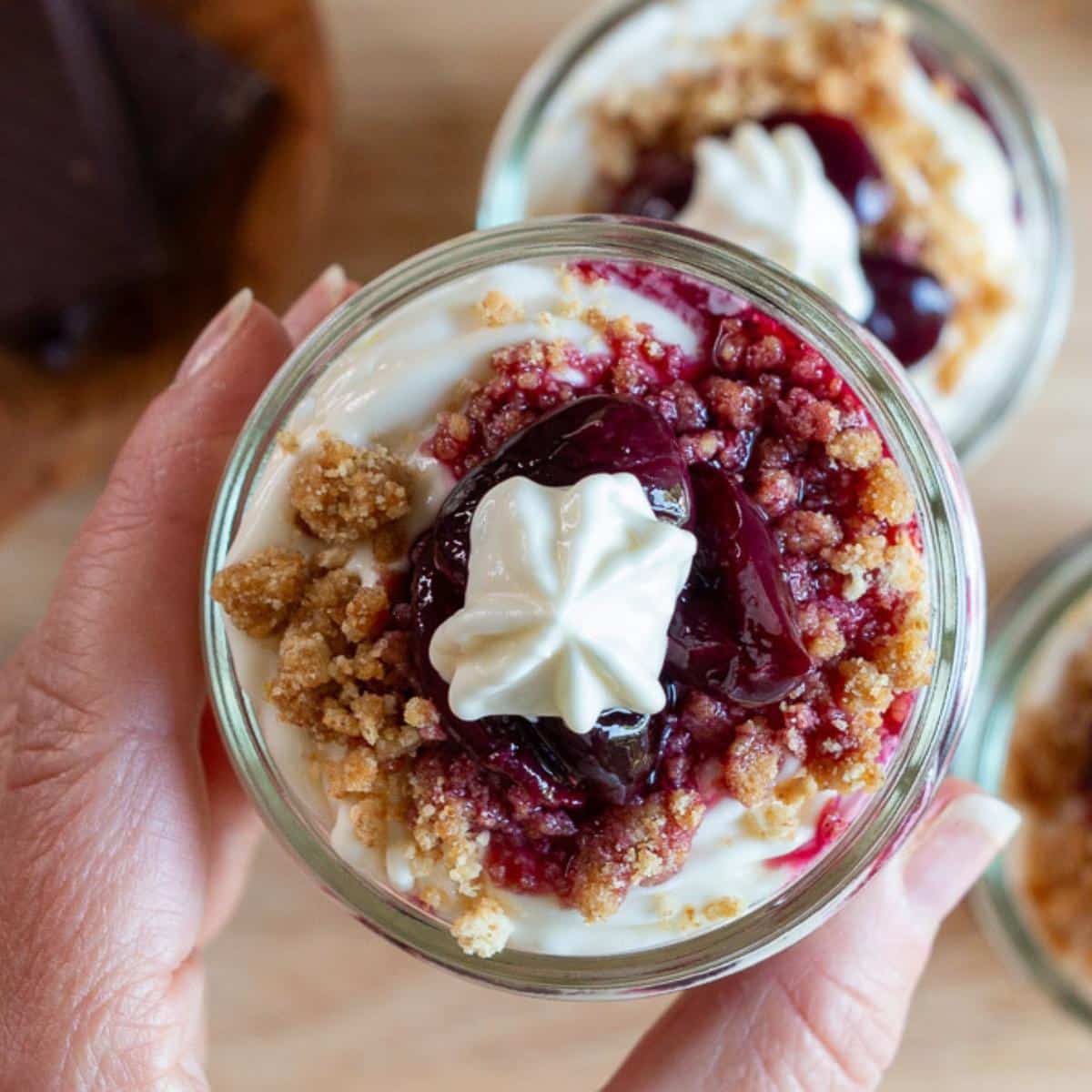 Top down shot showing the finished bourbon cherries on top of the cheesecake parfaits. 