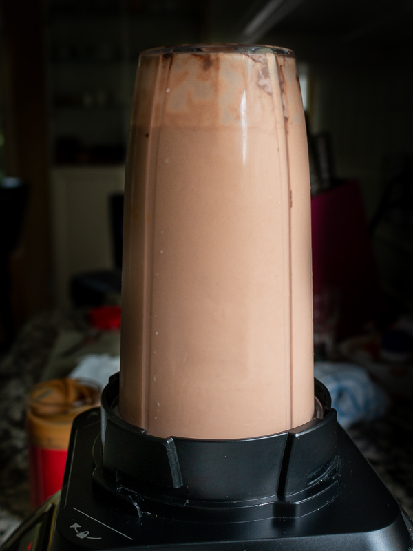 Smoothie ingredients in the Ninja Blender getting blended.