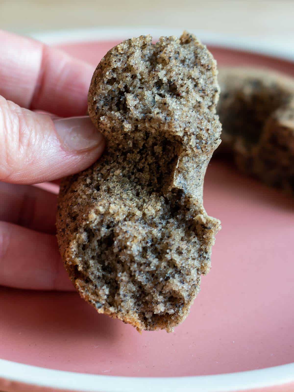 Baked black sesame mochi donut split in half showing the tender but chewy texture.