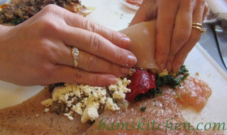 Chicken breasts getting rolled up. 