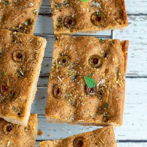 Cut wheat focaccia bread cooling on a wire rack.