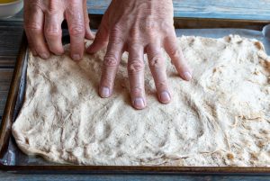 Spreading dough out in a baking sheet.