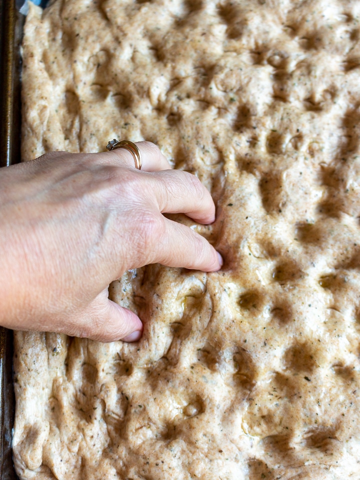 Putting dimplings in the dough with fingers.