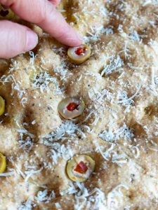 Adding olives to the dough.