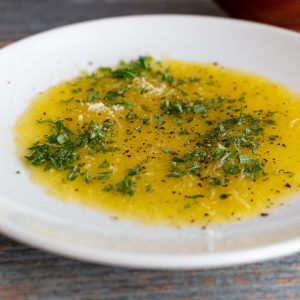 Herb oil on a white plate.