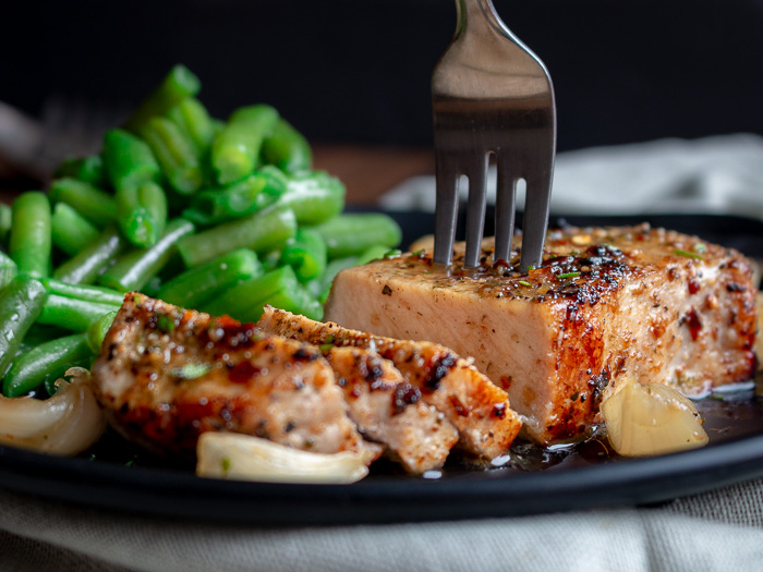 The bite shot. Juicy slices of Rosemary Herbed Pork chops with shallot wine sauce. 