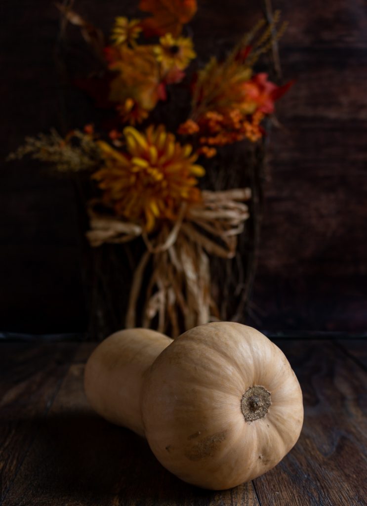 Whole butternut squash on a wooden table.