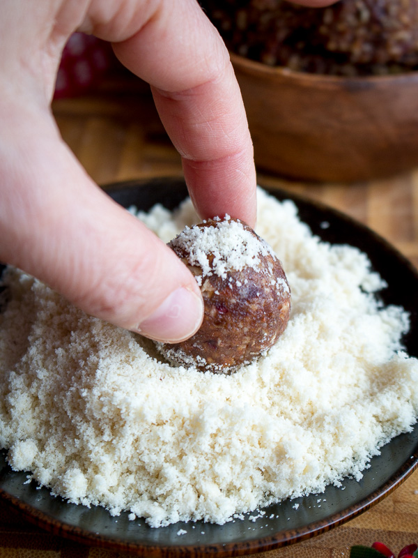 Dipping the bliss ball into the ground almonds.