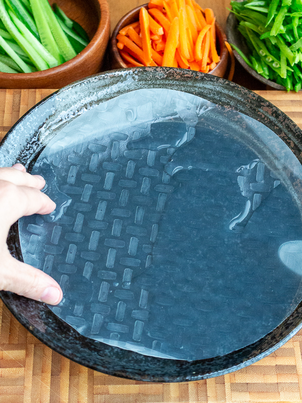 Soaking dried rice paper wrapper in water.