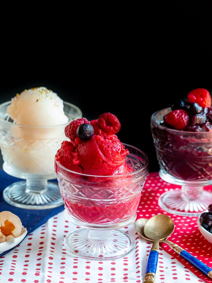 3 Healthy Sorbet recipes on a patriotic decorated table. Red, white and blue sorbets.