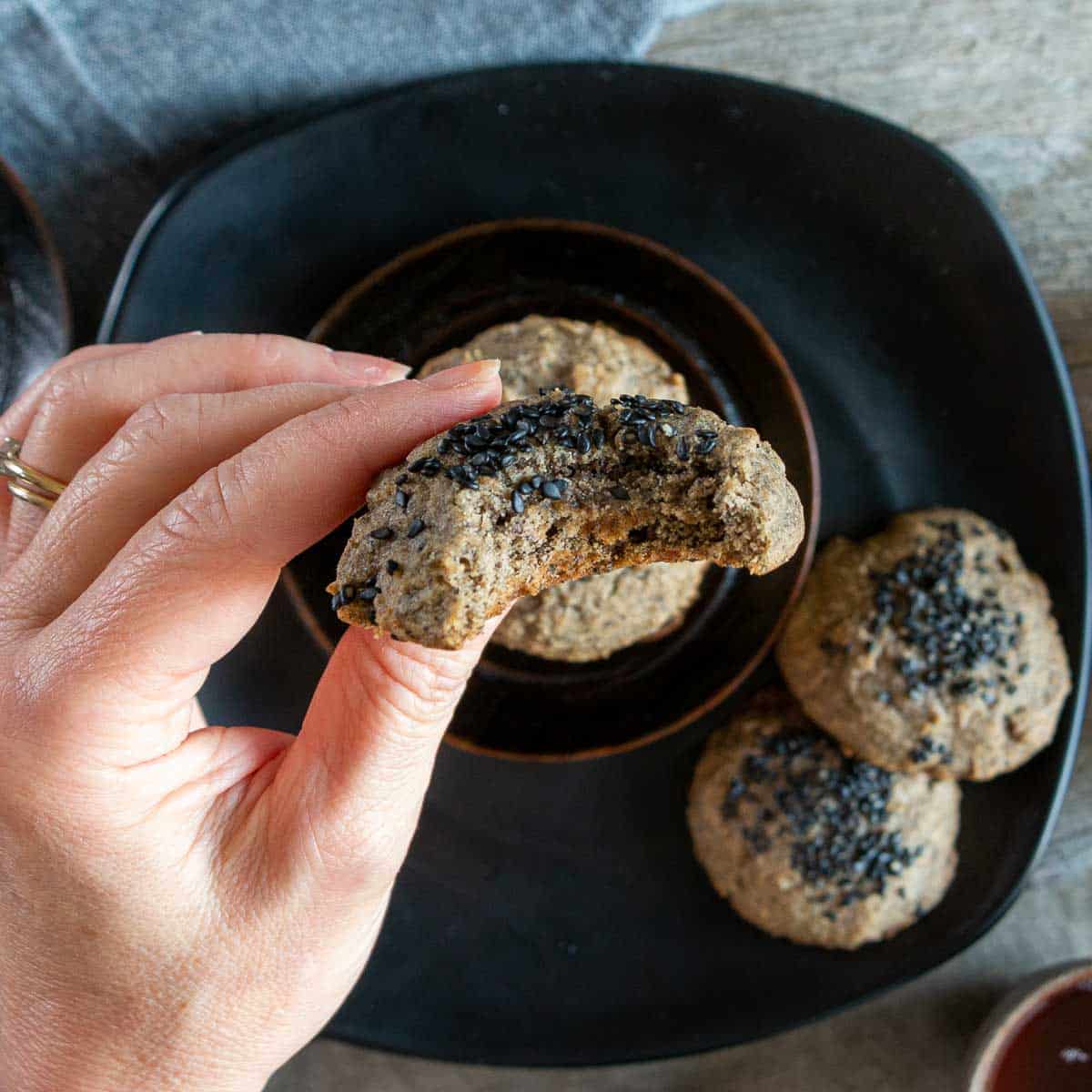 Big bite out of a cookie with a person holding it.