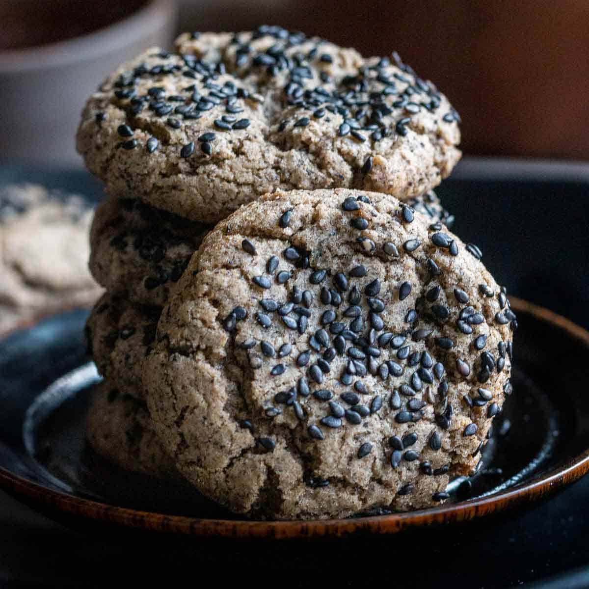 Tower of cookies on a black plate.