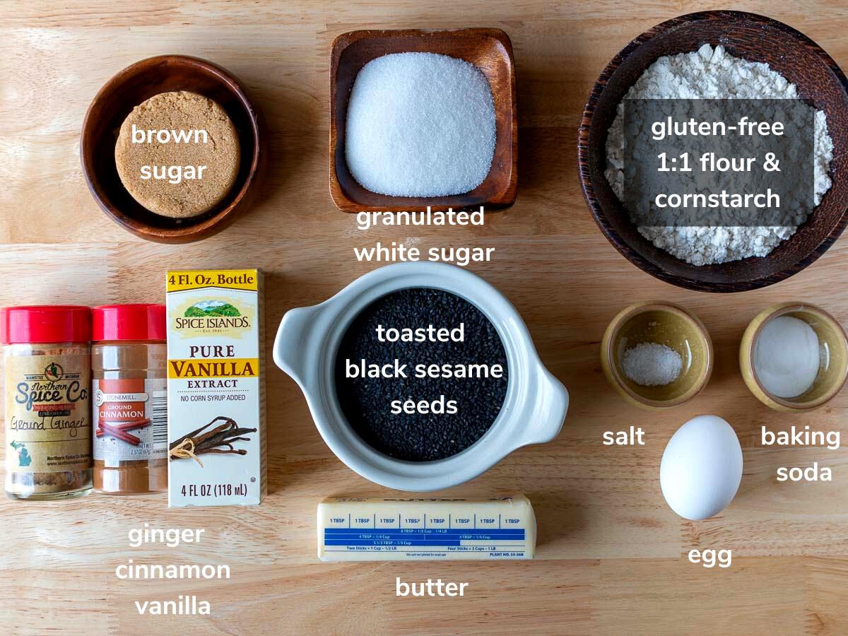 Ingredients to make black sesame cookies laid out on a wooden board.