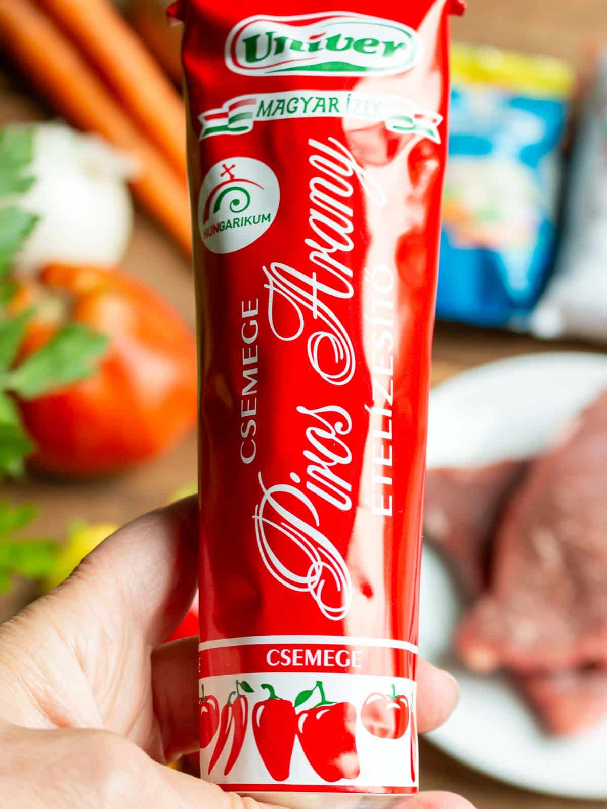 Holding a tube of store bought paprika cream - red gold.