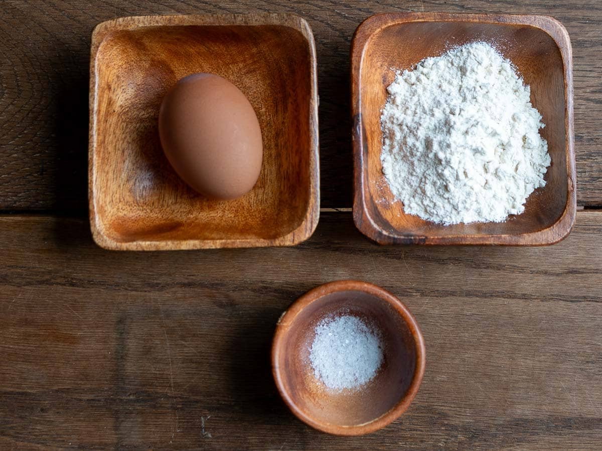 Ingredients to make petite soup dumplings on a wooden table. 