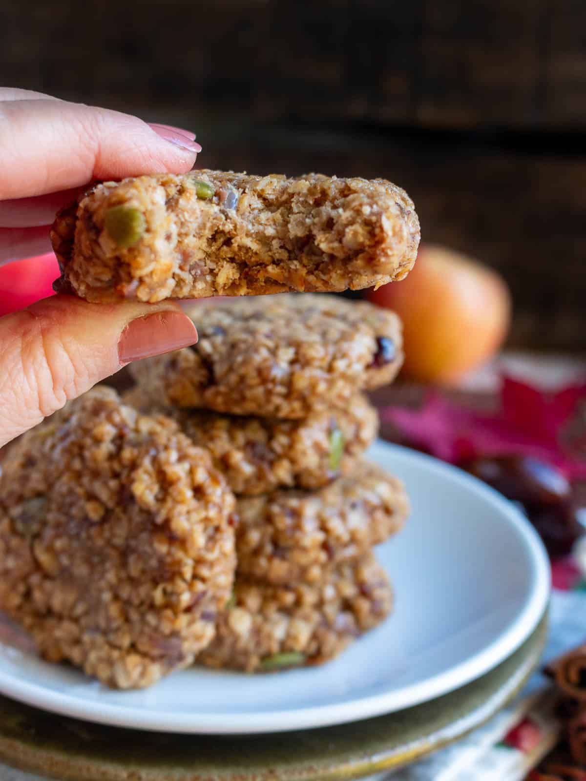 Taking a bite out of a baked chewy apple oatmeal date cookie.