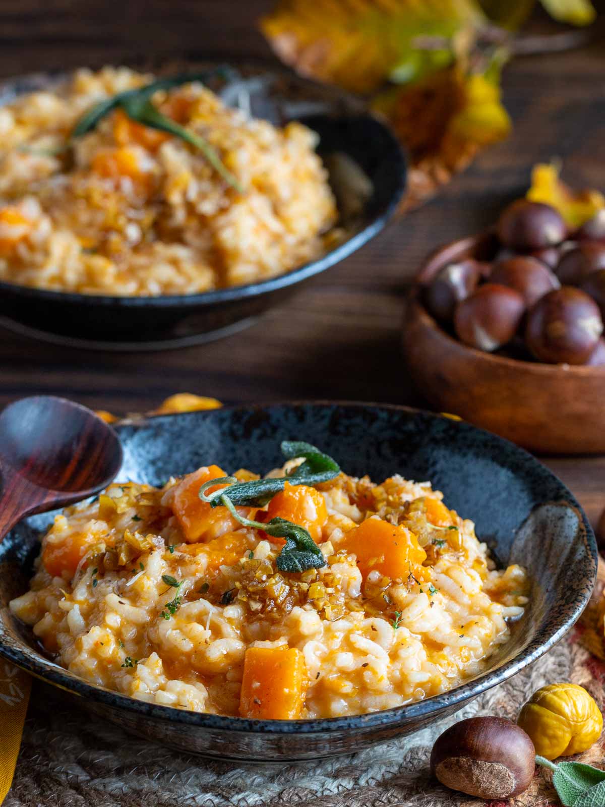 2 bowls of finished pumpkin risotto topped with parmesan cheese.