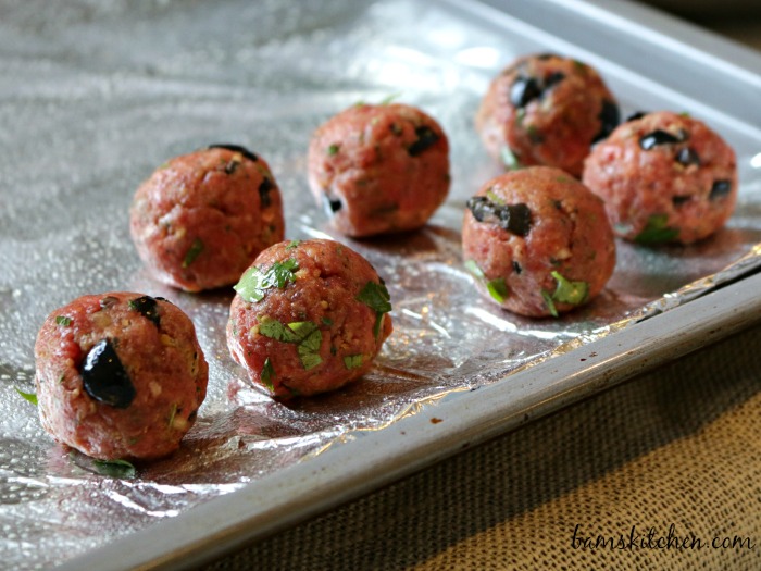 Spanish Olive Meatball ready for the oven on a baking sheet.