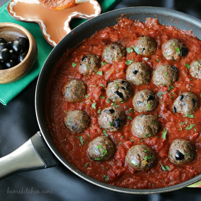 Spanish Meatballs with Pepper and Tomato Wine Sauce in a black pan.