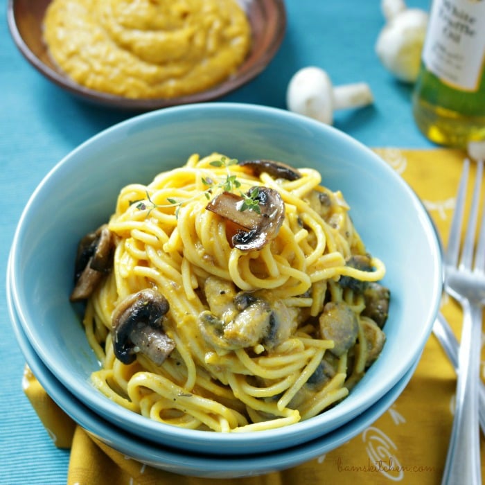 Vegan Kabocha Truffle Pasta in a blue bowl topped with mushrooms and thyme.