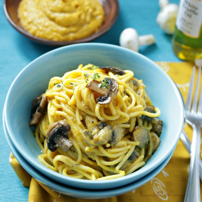 Vegan Kabocha Truffle Pasta in a blue bowl topped with mushrooms and thyme. 