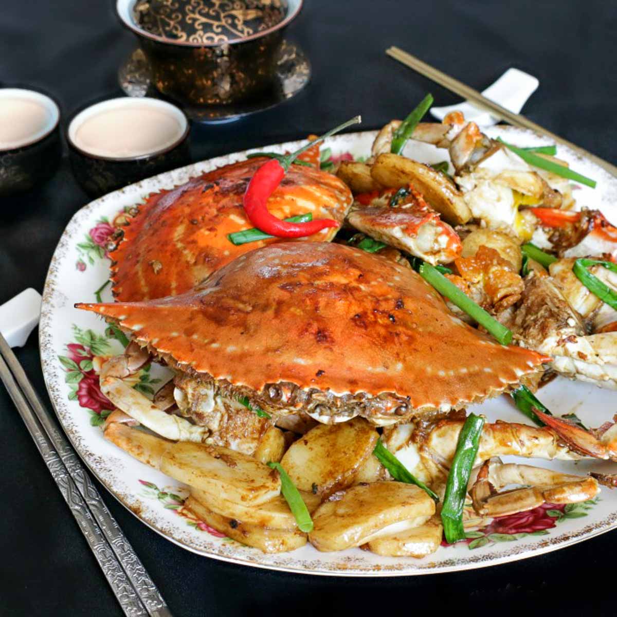 Stir fried crab with Chinese new year cakes on a white plate for Spring festival.