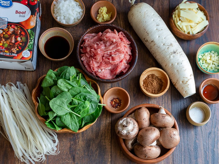 Soup ingredients laid out over a dark wooden board.