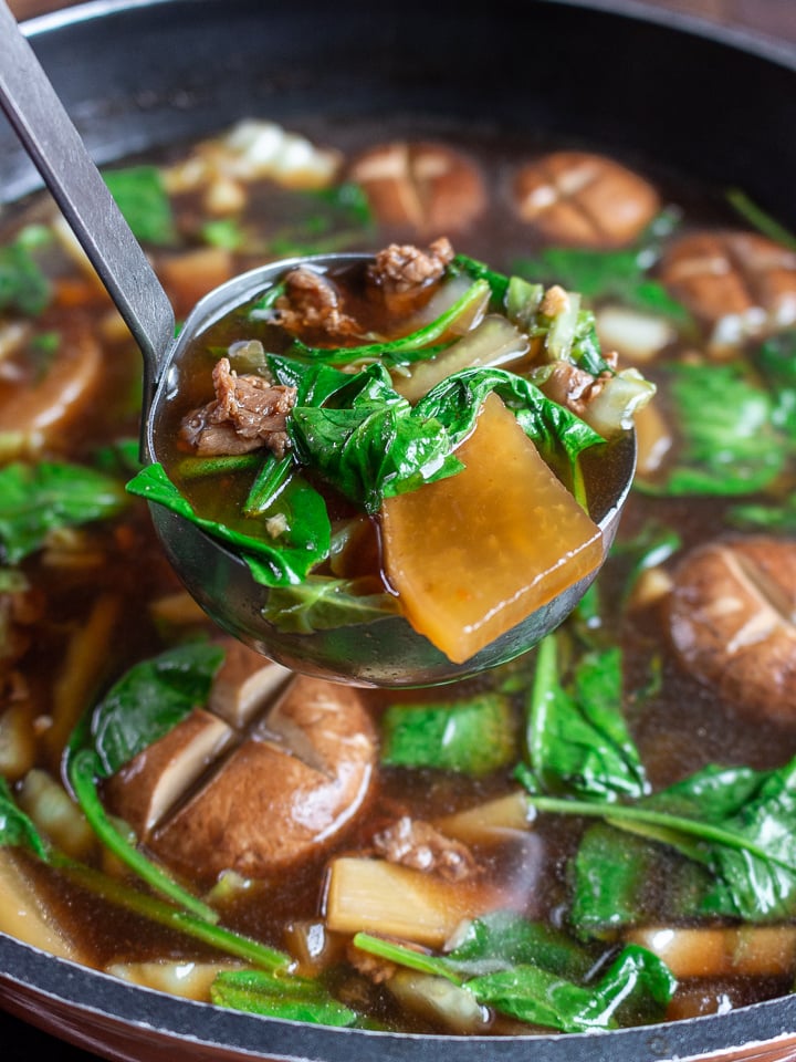 Delicious scoop of soup in a ladle ready to be served.