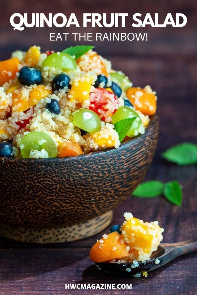Quinoa fruit salad in a wooden bowl garnished in mint with a wooden spoon.