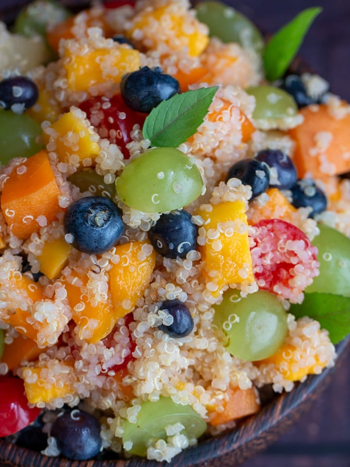 Close up shot of Quinoa Fruit Salad garnished with mint. 