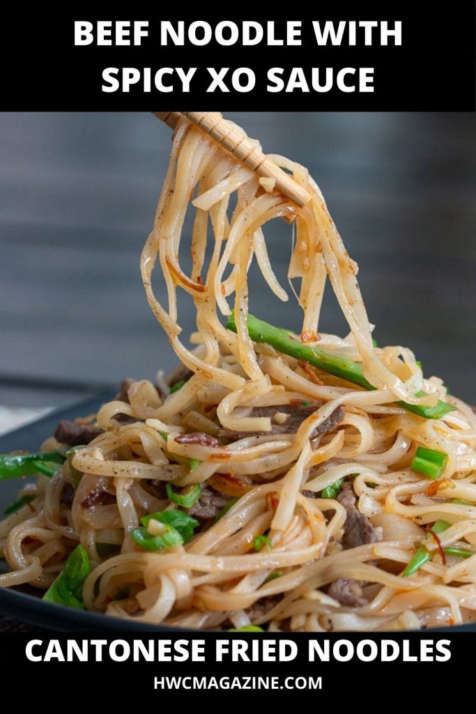 Pan fried Cantonese beef noodles with spicy XO sauce picked up with chopsticks.