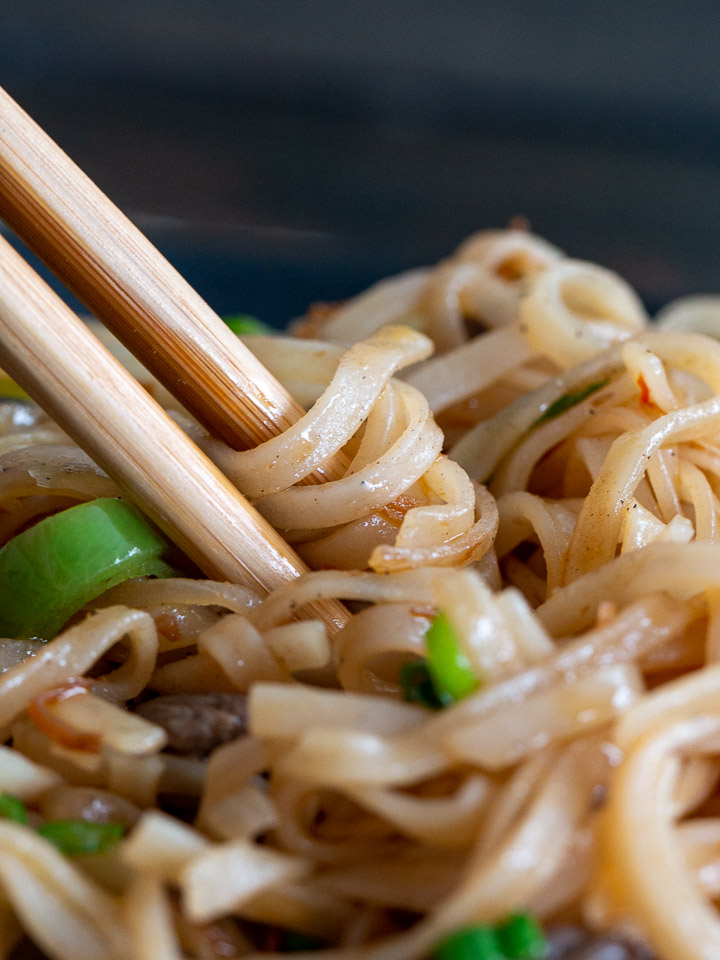 Noodles wrapped around chopsticks ready to eat. 