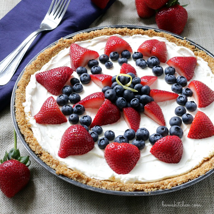 Skinny Berry Cheesecake Bars garnished with strawberries and blueberries.
