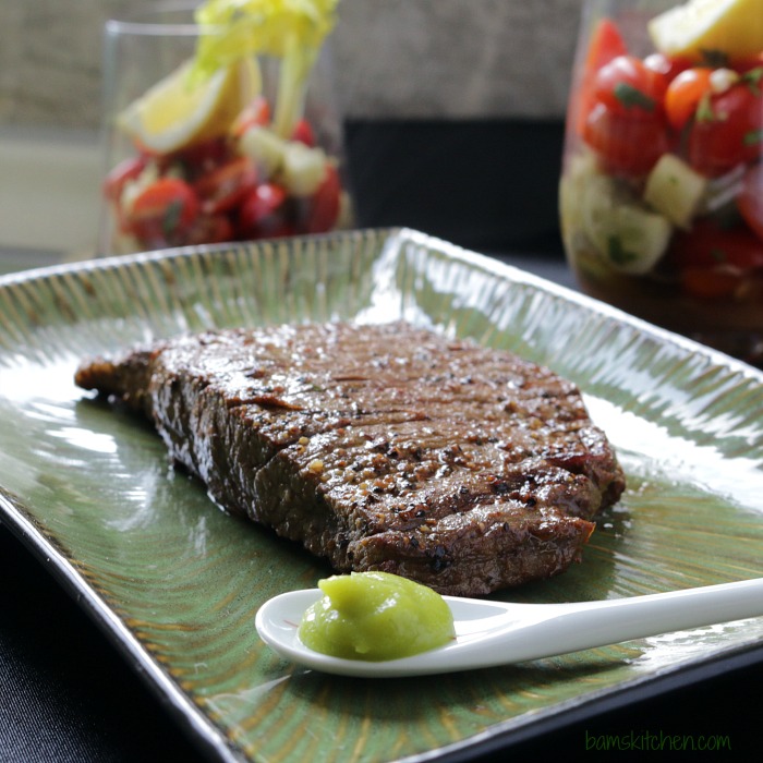 Grilled Steak right off the grill on a green plate.