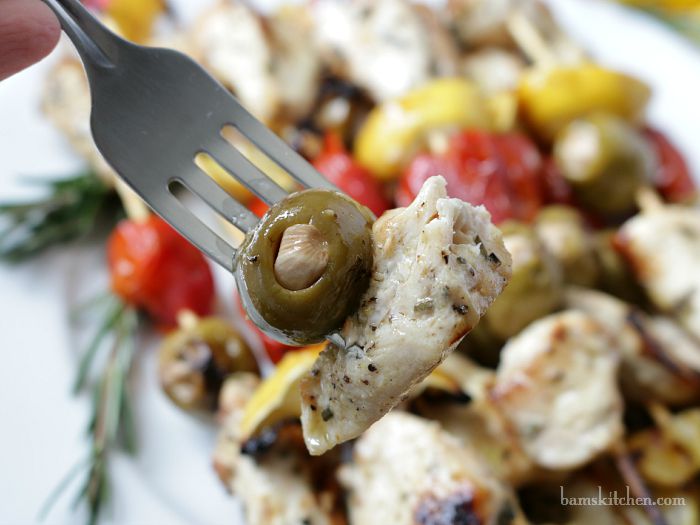 Bite Shot of a grilled olive and juicy chicken on a fork.