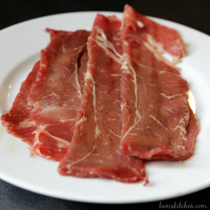 3 slices of raw thin sukiyaki beef.