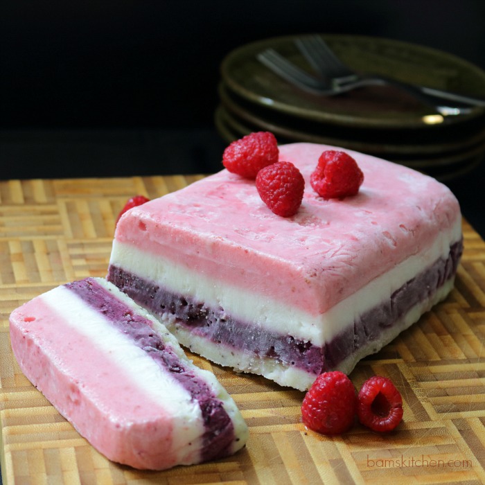 Rainbow Layered Fruit and Yogurt Ice Cream with plates and forks in the background.