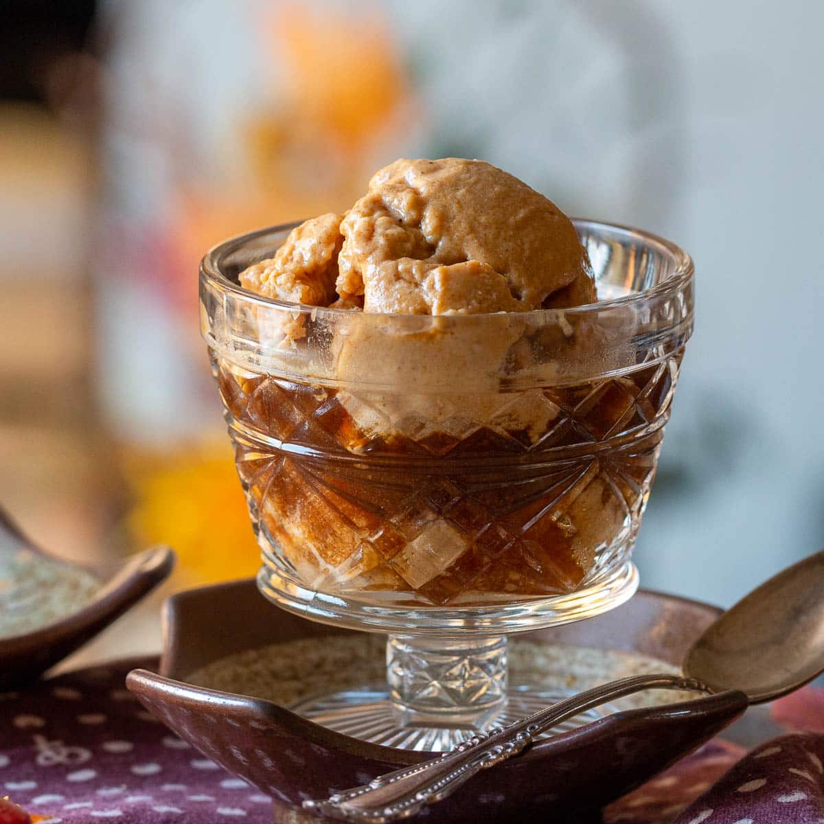Dairy free pumpkin ice cream affogato without any garnishes in a clear vintage glass.