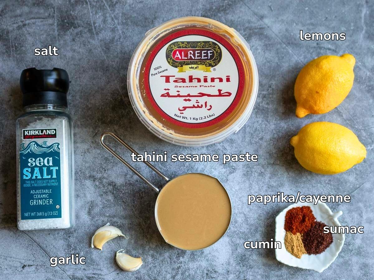 Ingredients to make an easy Tarator sauce laid out on a light gray blue table. 