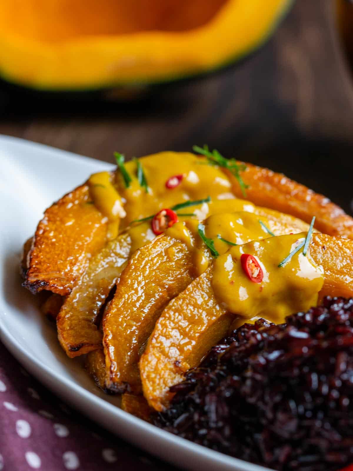 Thick Thai curry sauce drizzled over roasted kabocha squash and a side of black rice.