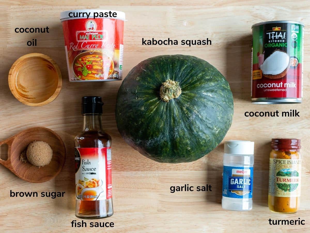 Ingredients to make air fryer kabocha squash with the Thai curried sauce laid out on a wooden board.