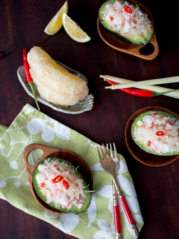 Top down photo showing the peeled pomelo segments and 3 avocado boats on three little wooden Thai bowls.