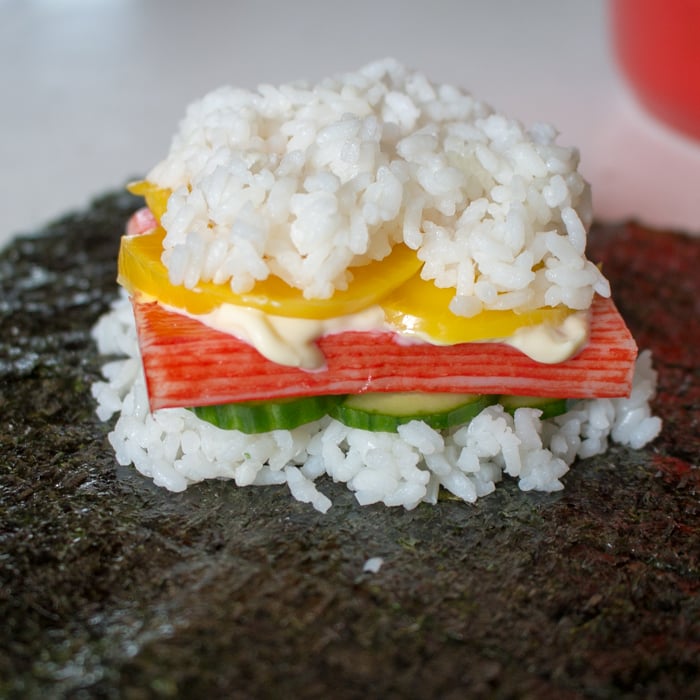 Layers of sushi rice, vegetables, crab and Kewpie mayo on top of nori.