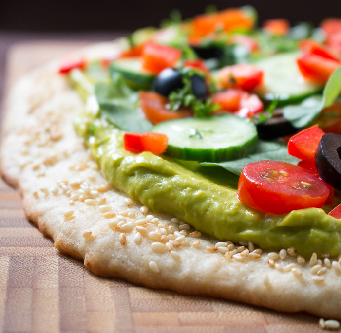 Showing the edges of the sesame rimmed gluten-free crust and a nice layer of guacamole. 