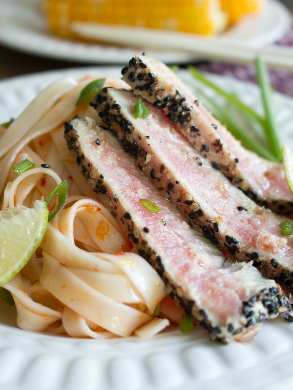 Noodles tossed with garlic chili sauce and a wedge of lime.