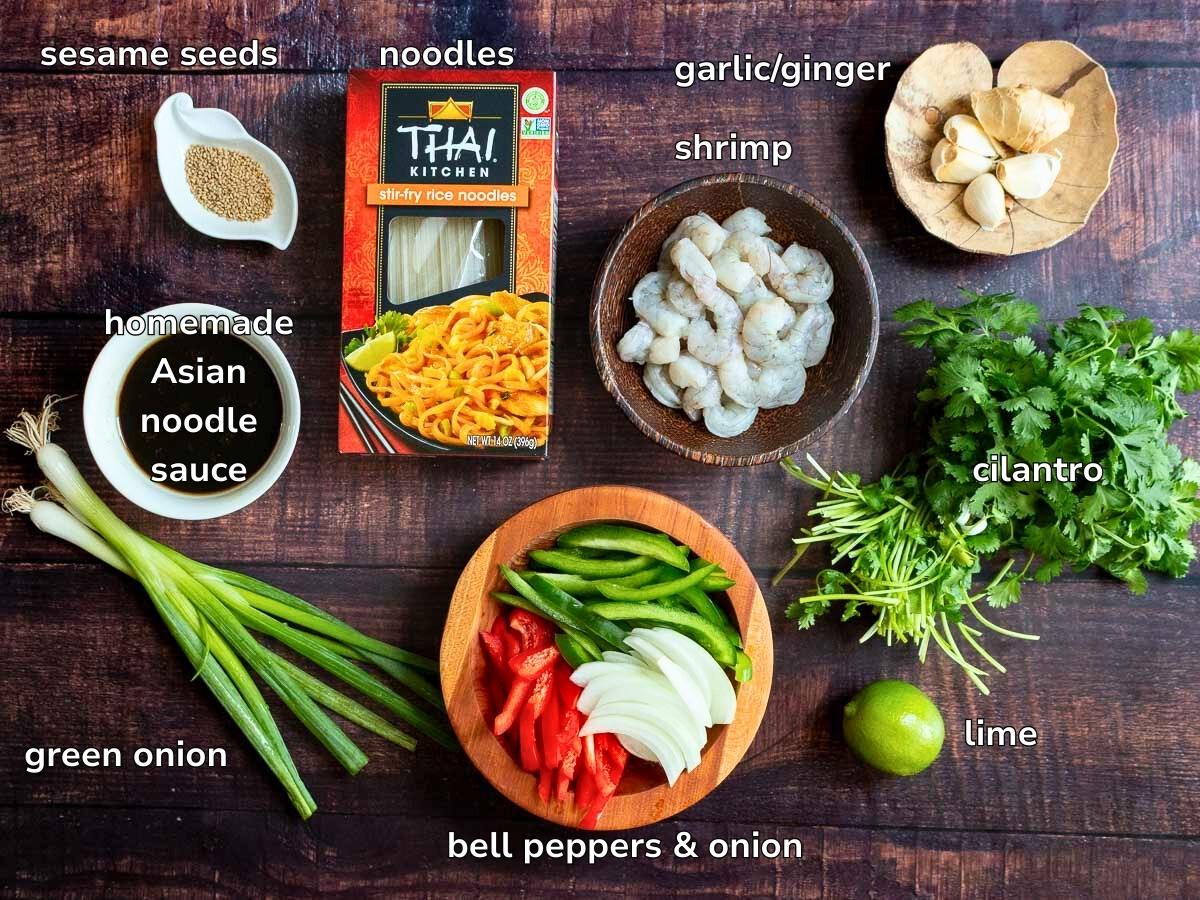 Ingredients to make an easy shrimp , veggie and noodle stir fry on a wooden table. 