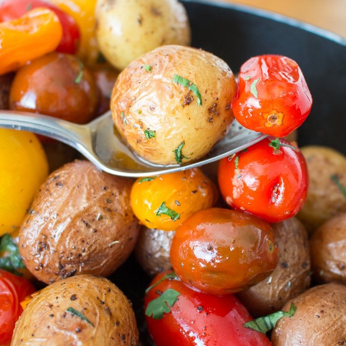 Potatoes and tomatoes on a spoon.