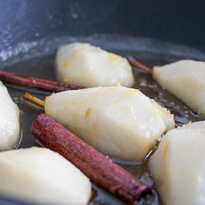 Pears in a pan cooking with spices.
