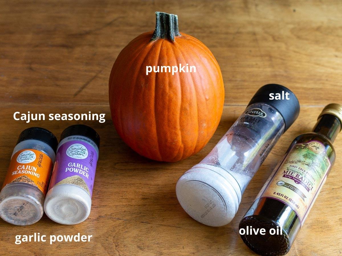 Ingredients to make air fryer pumpkin seeds on a wooden board.